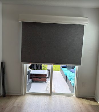 Custom blackout roller shade installed over a sliding glass door in a St. Augustine home