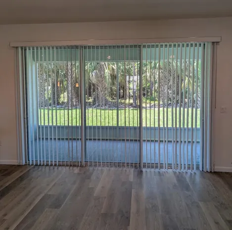 Custom vertical blinds covering a wide sliding glass door in a St. Augustine home