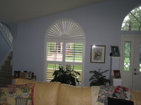 Sunburst and rectangular plantation shutters in a St. Augustine living room